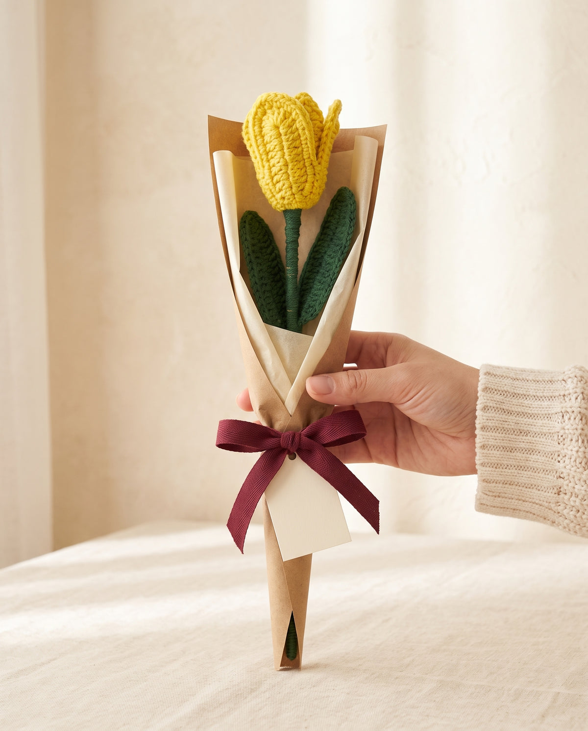 Single crochet yellow tulip stem wrapped in kraft paper with ribbon