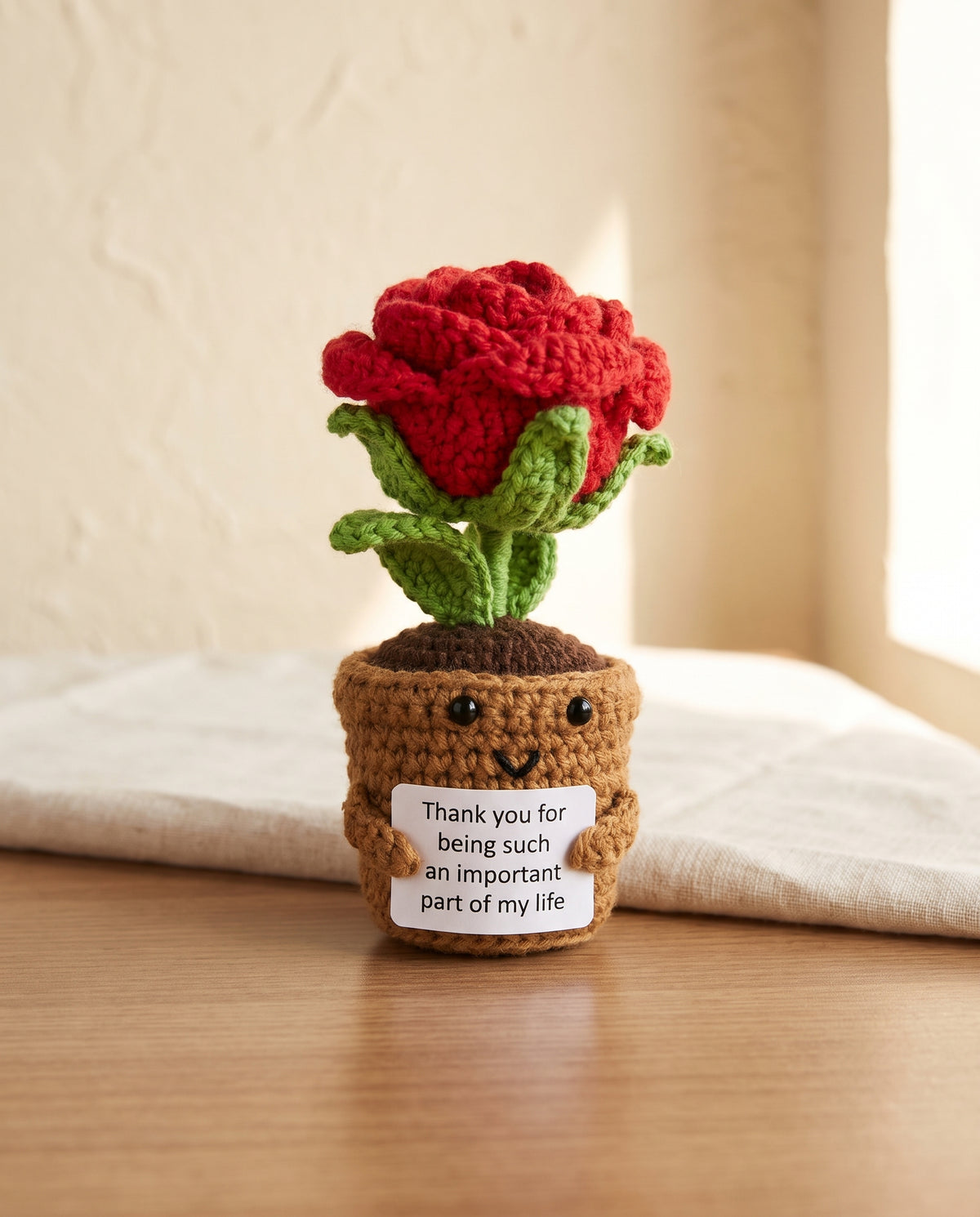 Crochet rose pot desk buddy holding a thank you card