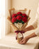 Wrapped bouquet of 5 crochet red roses held in two hands