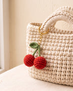 Crochet cherry charm on a tote bag