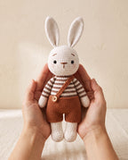 Crochet bunny doll held in two hands to show its size