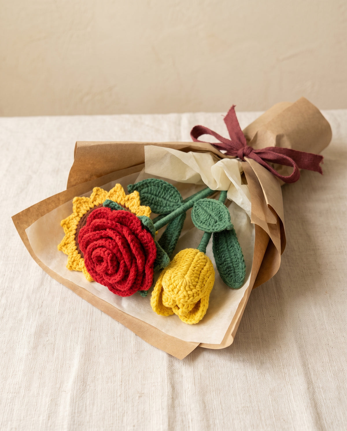 Wrapped crochet bouquet of a rose, a sunflower and a tulip