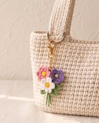 Crochet mini flower bouquet charm on a tote bag