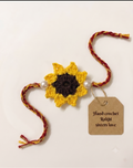 Handmade yellow crochet sunflower rakhi with brown centre and twin pearls