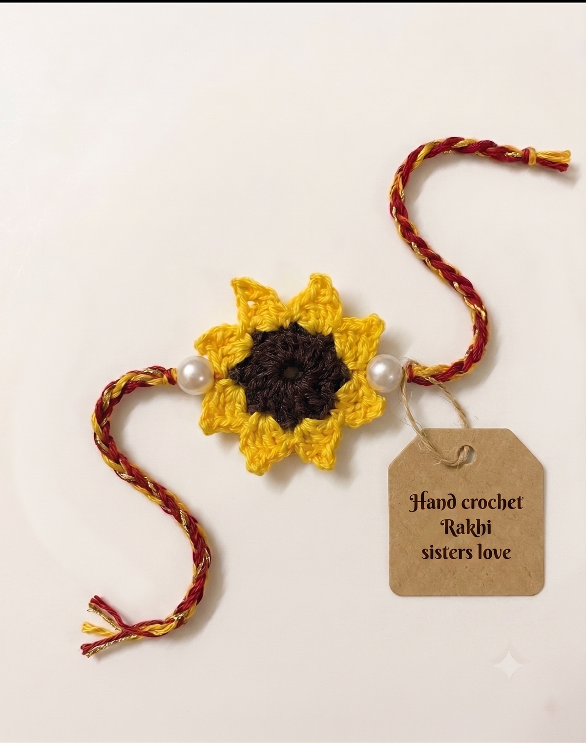 Handmade yellow crochet sunflower rakhi with brown centre and twin pearls