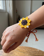 Handmade yellow crochet sunflower rakhi with brown centre and twin pearls