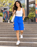 Woman walking down steps in the cobalt granny square crochet Bermuda shorts