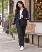 Woman wearing a charcoal granny square crochet zip hoodie on a city street