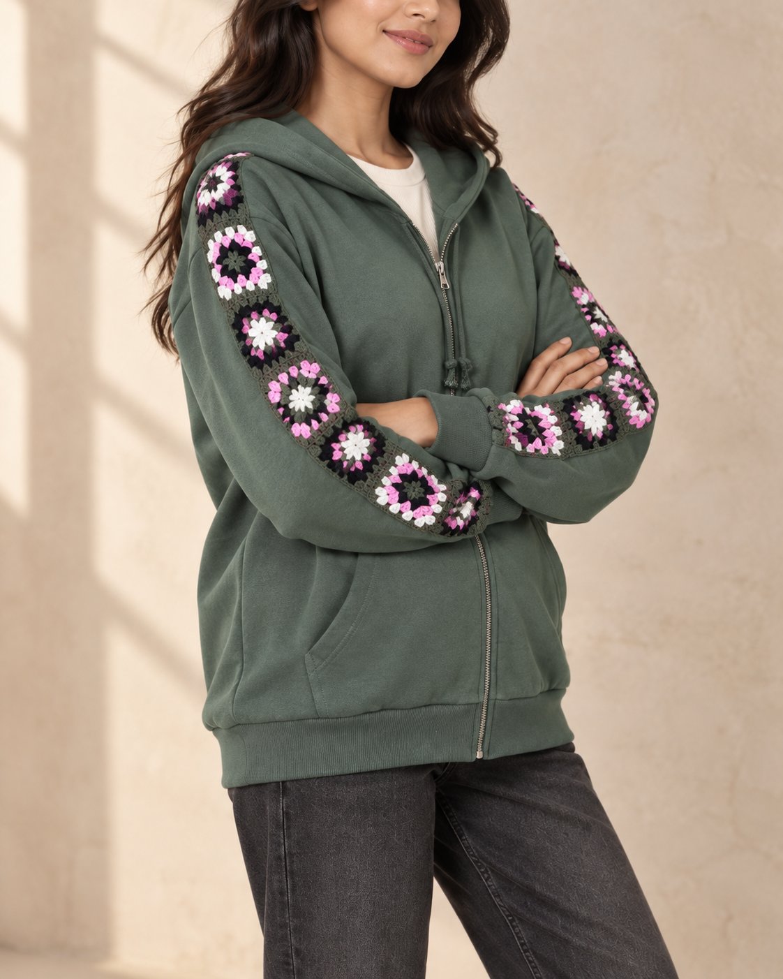 Sage green zip hoodie with pink and white hand-crocheted granny square sleeve panels